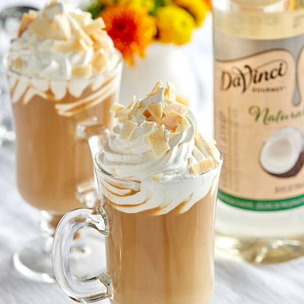 Two glasses of coffee with whipped cream and coconut flakes using DaVinci Gourmet All-Natural Coconut Flavoring Syrup.