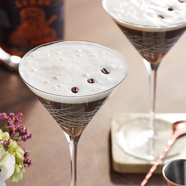 Two martini glasses of Lyre's Coffee Originale with coffee beans in them.
