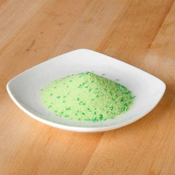 A white plate of green apple cocktail rimming sugar.