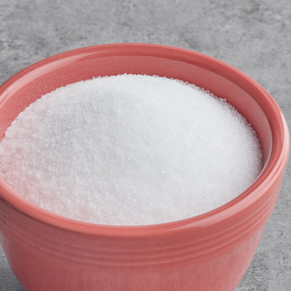 A bowl of Regal Stevia sweetener on a gray surface.