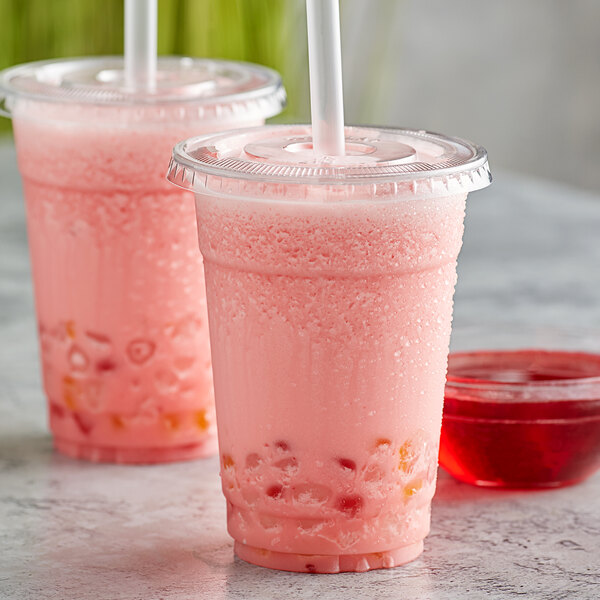 Two plastic cups of pink Bossen raspberry drink with straws.