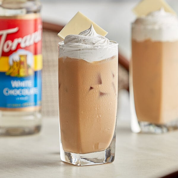 Two glasses of iced coffee with whipped cream and Torani White Chocolate syrup.