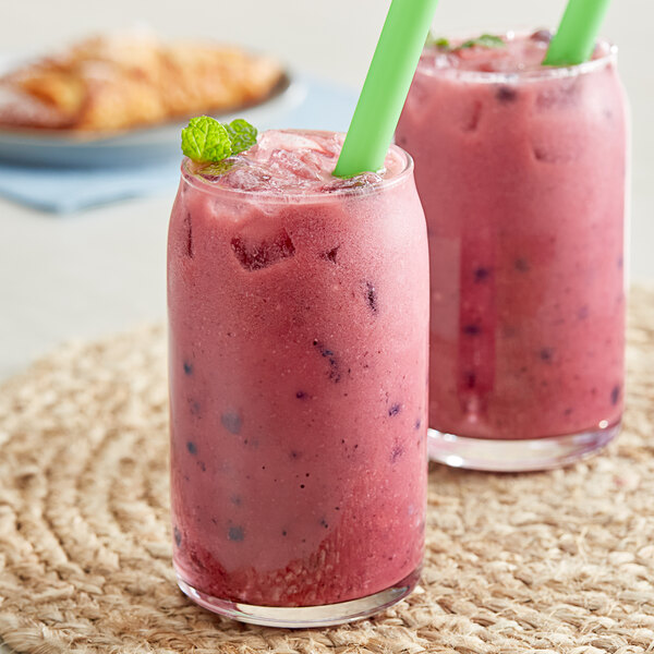 Two glasses of pink Bossen mulberry smoothies with green straws.