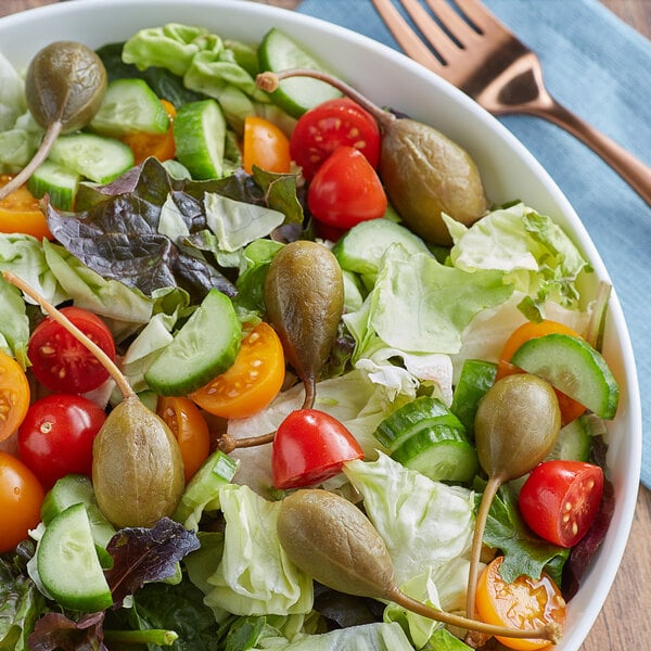 A bowl of salad with tomatoes and capers.