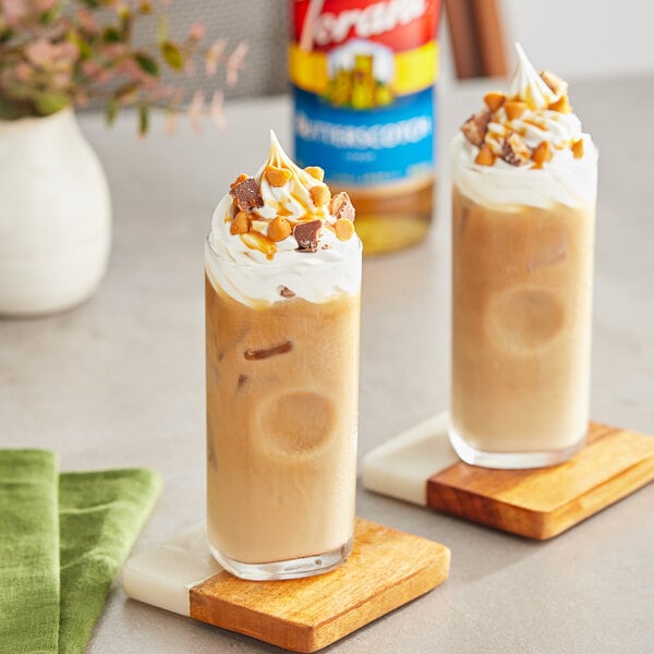 Two glasses of coffee flavored with Torani Butterscotch syrup, topped with whipped cream and nuts.