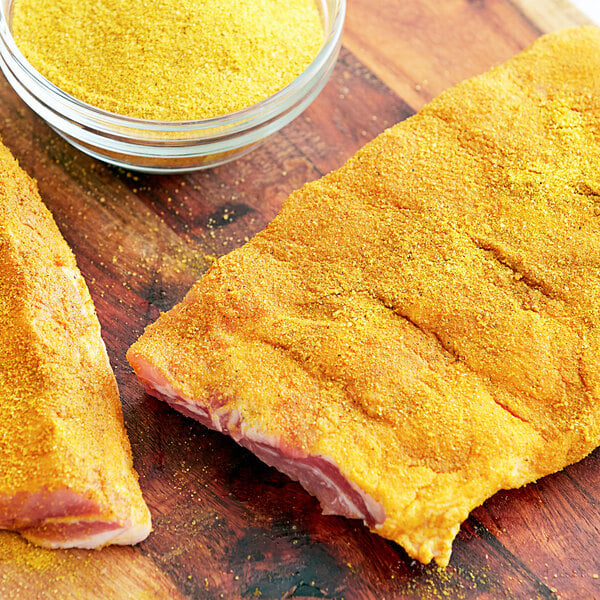 Two pieces of meat with Regal Seasoned Salt on a cutting board.