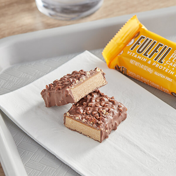 A tray with two chocolate, peanut, and caramel FULFIL protein bars.