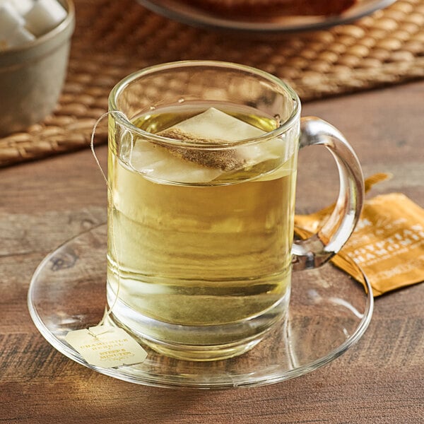 A glass mug of Harney & Sons chamomile tea with a tea bag in it.