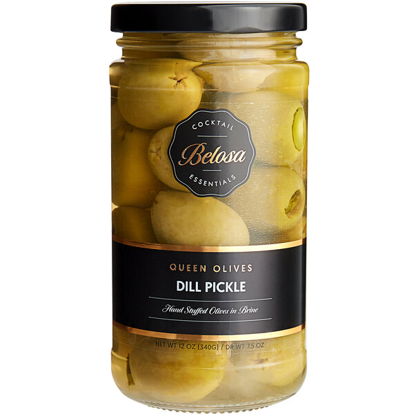 A jar of Belosa Dill Pickle Stuffed Queen Olives on a table with a yellow label.