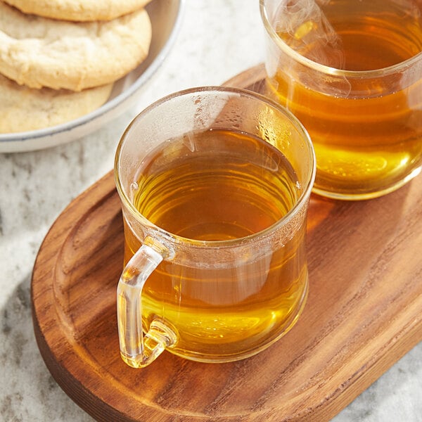 A wooden tray with two Twinings Pure Chamomile tea mugs and a stack of cookies.