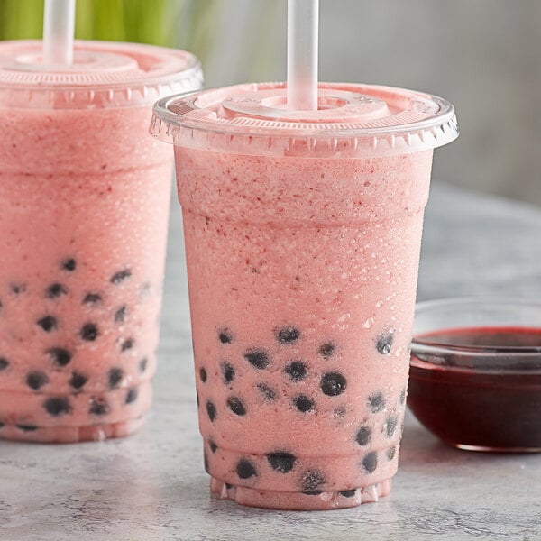 Two plastic cups of Bossen dragon fruit drinks with black balls and straws.