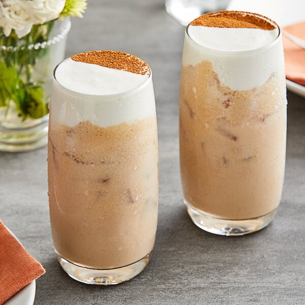 Two glasses of drinks with Fanale Whipping Cheese on top on a table.