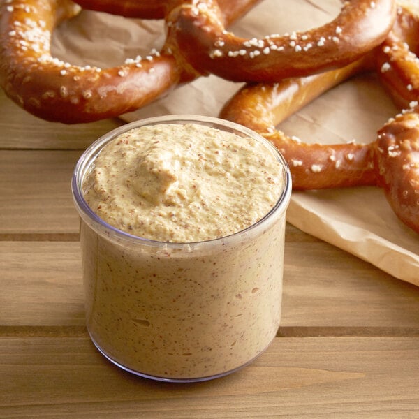 A pretzel with a jar of Regal Yellow Mustard.