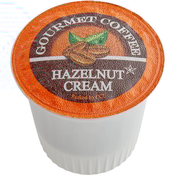 A white container of Caffe de Aroma Hazelnut Cream coffee single serve cups with an orange label.