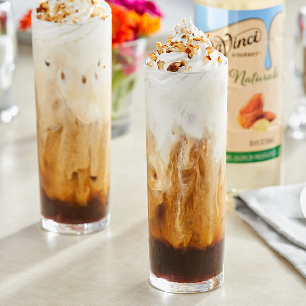 Two glasses of almond-flavored drinks with whipped cream and nuts.