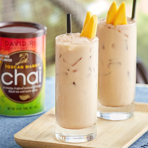 A glass of David Rio Toucan Mango Chai Tea on a table.