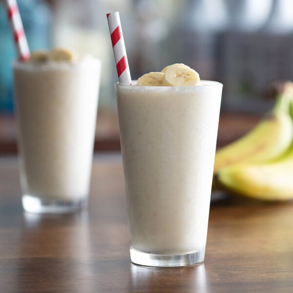 Two glasses of banana smoothie with straws made with Monin Banana Fruit Puree.