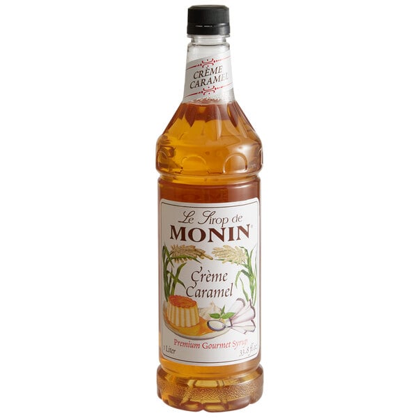 A Monin Creme Caramel syrup bottle with brown liquid and a label.