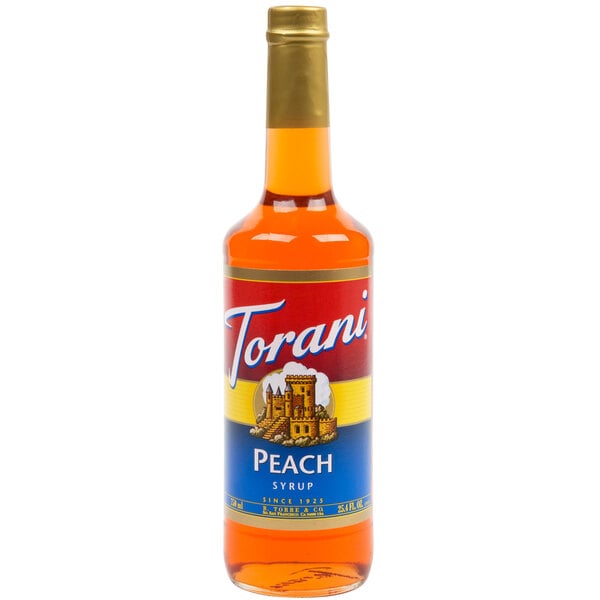 A Torani Peach syrup bottle on a table with a label.