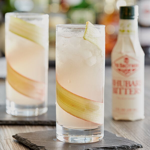 A glass of Fee Brothers rhubarb bitters with a slice of apple in the liquid.