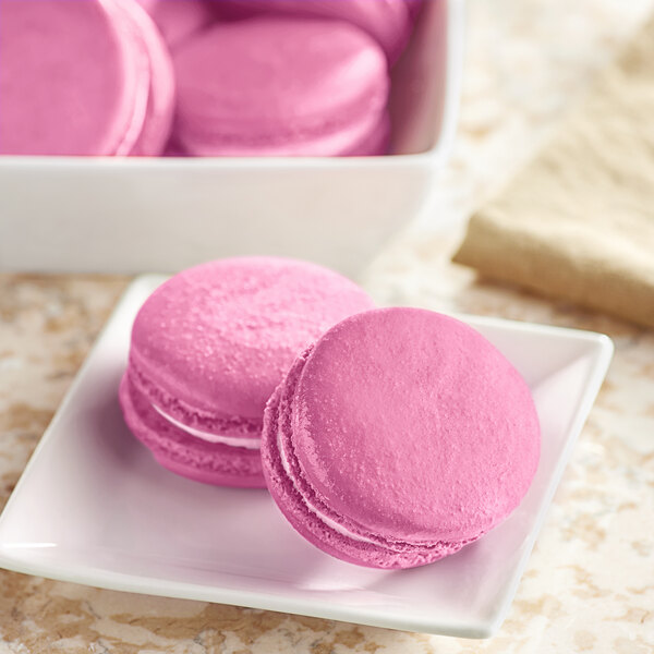 Pink macarons on a white plate.