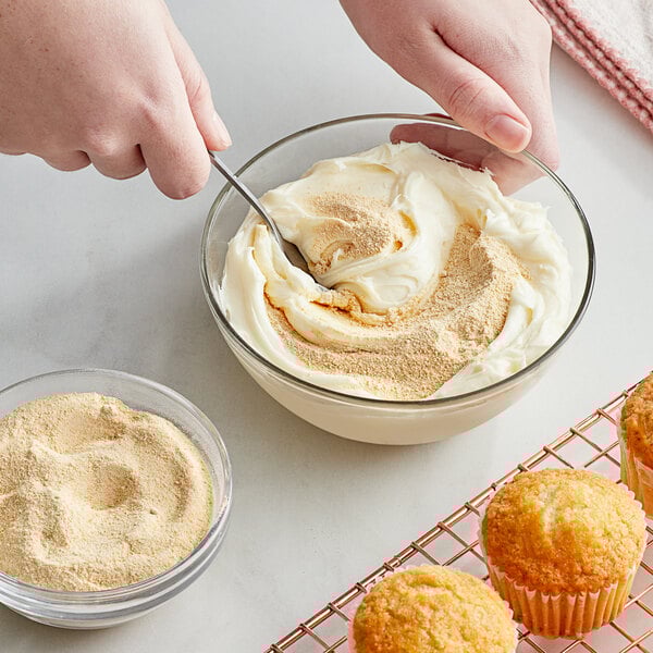 A person mixing Regal Maple Sugar in a bowl of food.