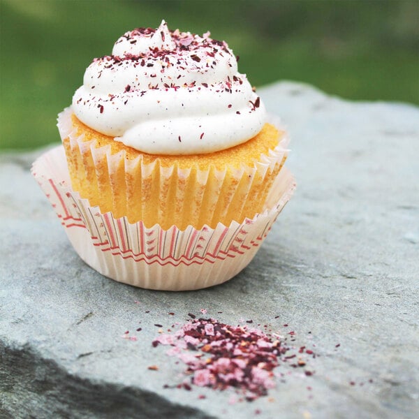 A cupcake with white frosting and sprinkles on Wild Hibiscus Hibiscus Pyramid salt flakes.