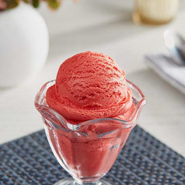 A glass cup with a scoop of pink I. Rice Watermelon Hard Serve Ice Cream.