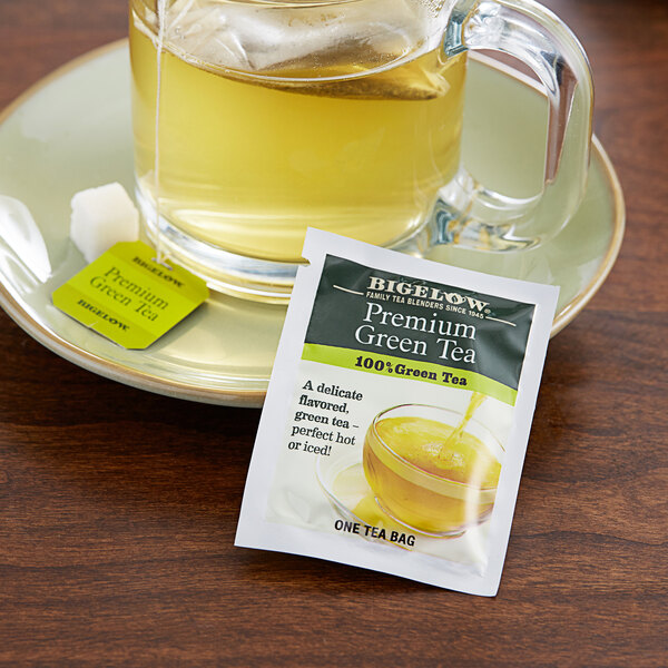 A glass of green tea with a Bigelow green tea bag on the table.