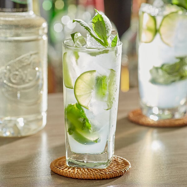 Two glasses of mojito with mint and lime on a table in a cocktail bar.