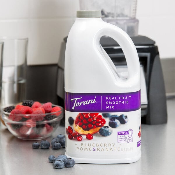 A white jug with a purple Torani label filled with a blue liquid.