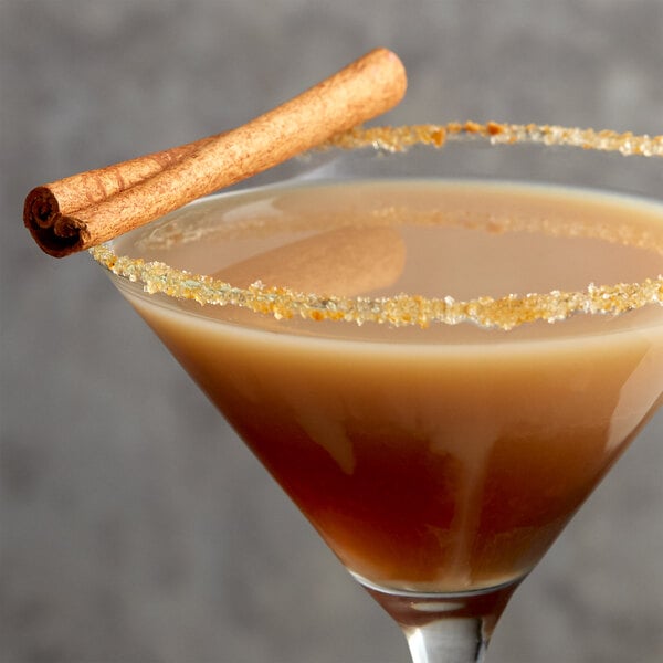 A brown cocktail with a cinnamon stick garnish.