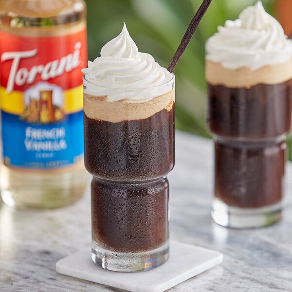 A glass of French vanilla iced coffee with whipped cream and chocolate syrup on the rim.