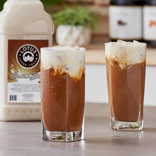 A close-up of two glasses of brown Lotus Plant Energy drinks.