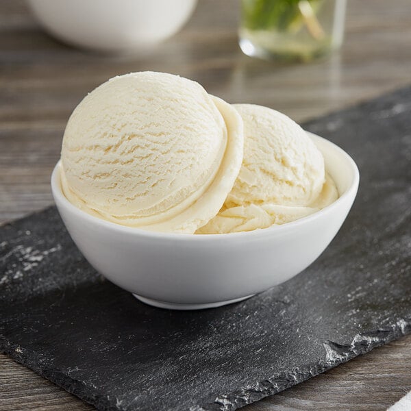 A bowl of I. Rice banana hard serve ice cream on a white surface with a black border.