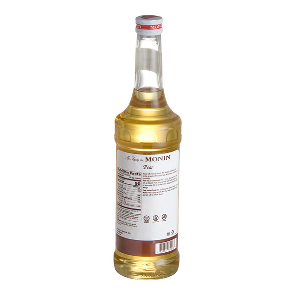 A Monin pear syrup bottle with a label on a white background.