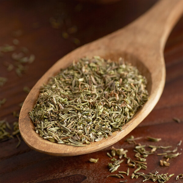 A wooden spoon filled with Regal dried thyme leaves.