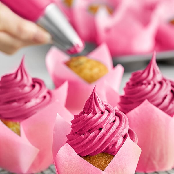 A close-up of a cupcake with pink frosting made with Chefmaster Fuchsia Liqua-Gel.