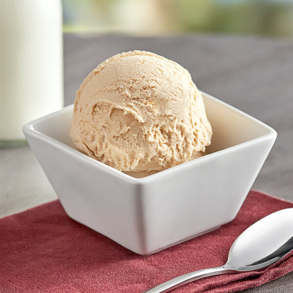 A bowl of Oringer salty caramel ice cream with a spoon on a red cloth.