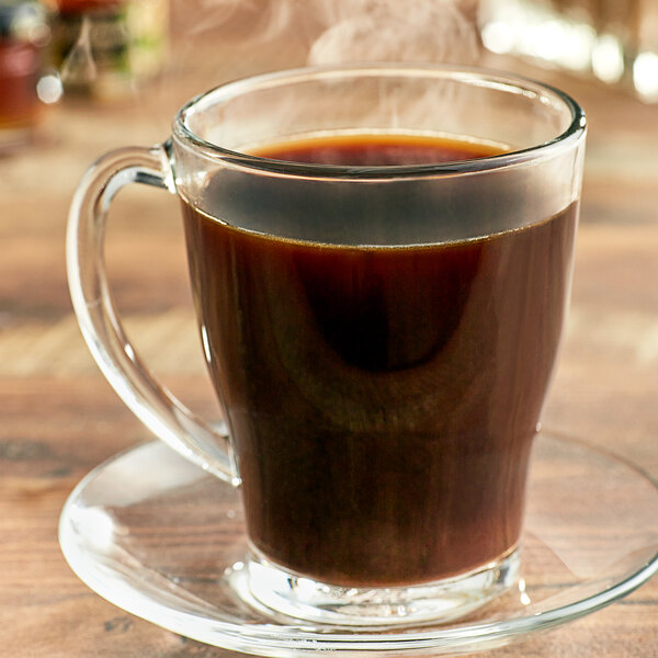 A glass cup of Ellis Mezzaroma Royal Sumatra coffee with steam rising from it.