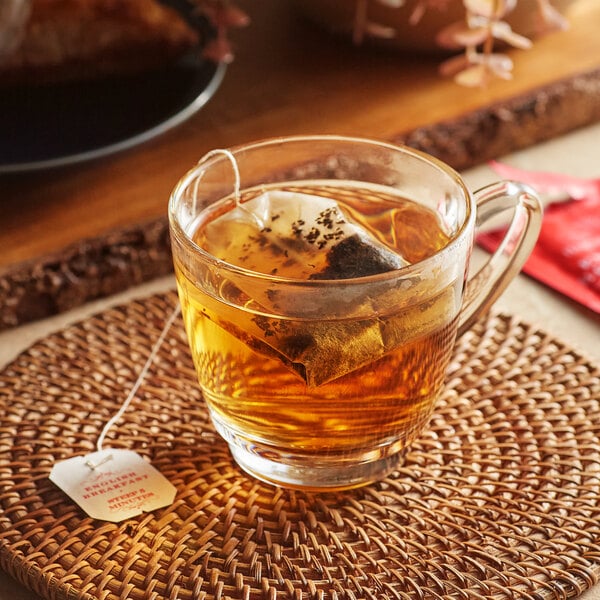 A glass cup of Harney & Sons English Breakfast Tea with a tea bag in it.