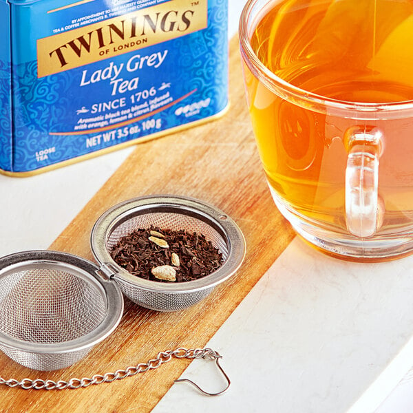 A close-up of a glass cup of Twinings Lady Grey tea.