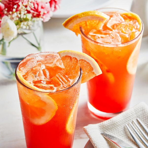 A pair of glasses with Fanale grapefruit syrup drinks and lemon slices.