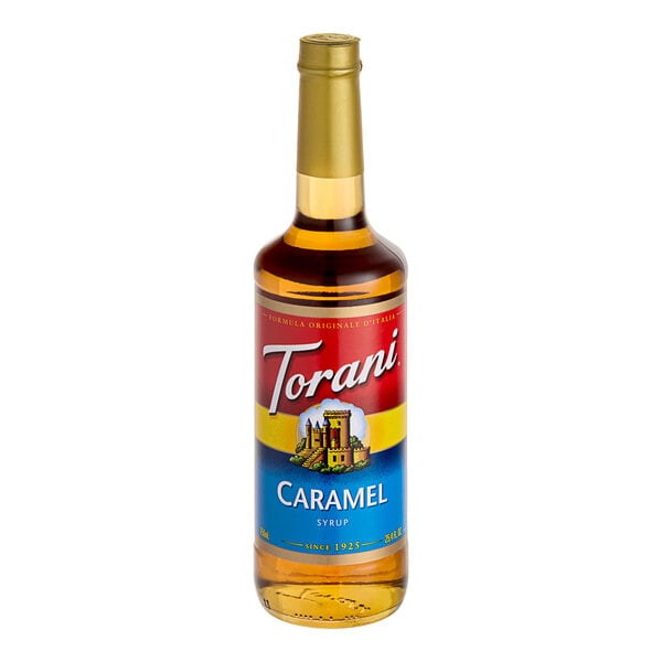 A close-up of a Torani Caramel Flavoring Syrup bottle with a label.