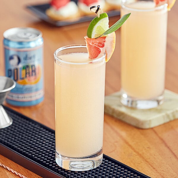 A glass of Polar Diet Pink Grapefruit Juice on a bar with garnish.