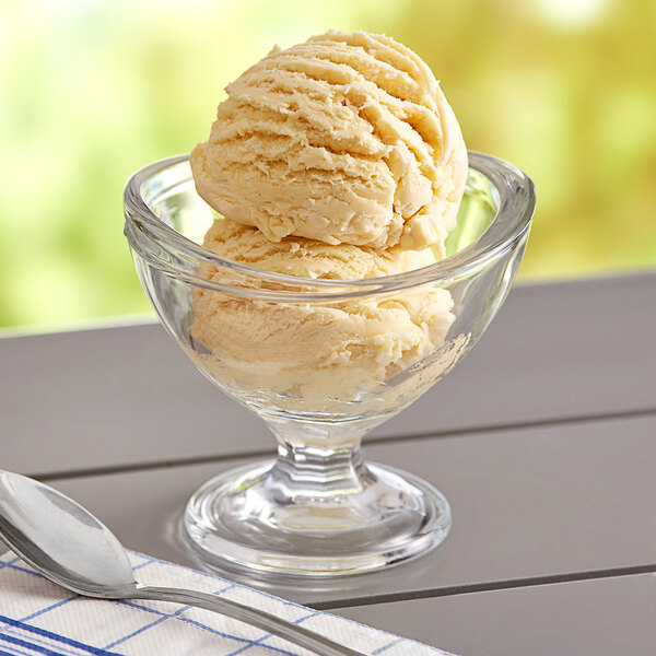 A bowl of Oringer butterscotch ice cream with a spoon on a napkin.