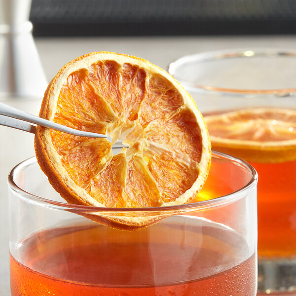 Dried orange slice in a glass of liquid.