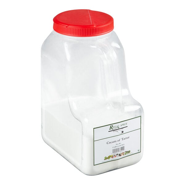 A large plastic container of Regal brand cream of tartar with a red lid.