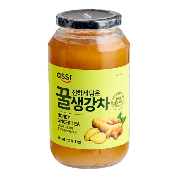 A case of Assi Korean Citron Tea with Honey jars on a table in a deli with green labels.