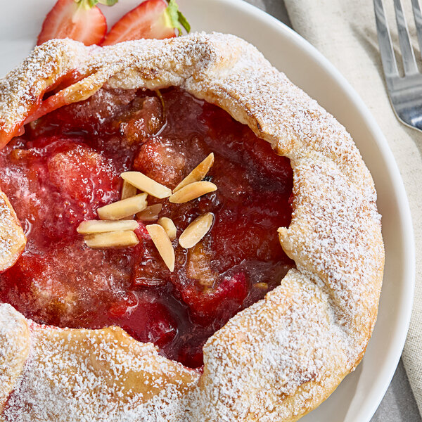 A pastry with a Monin Strawberry Rhubarb Puree topping and almonds on top.